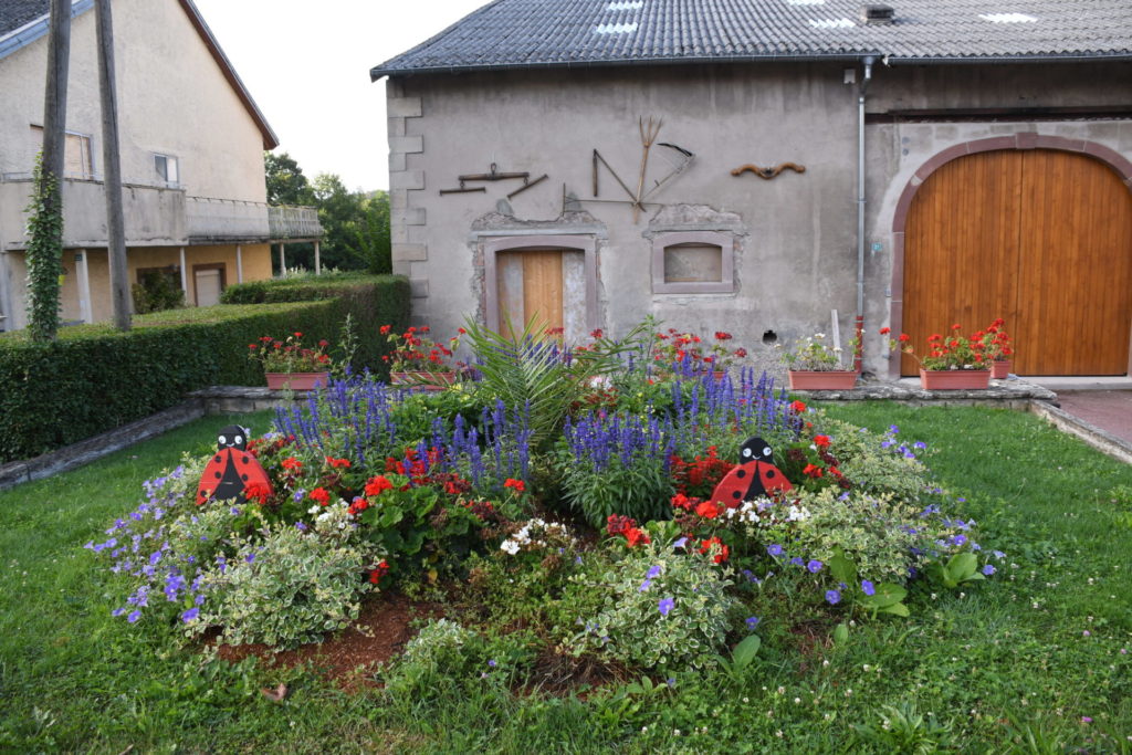 Village fleuri Héming à coté de la fontaine